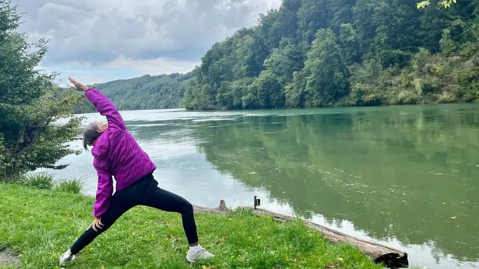 רויטל מתרגלת יוגה על שפת נהר הריין בטיול אופניים בשוויץ
